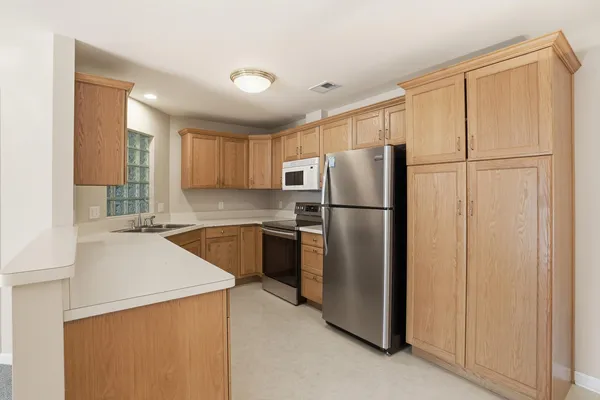 a kitchen with a refrigerator sink and cabinets