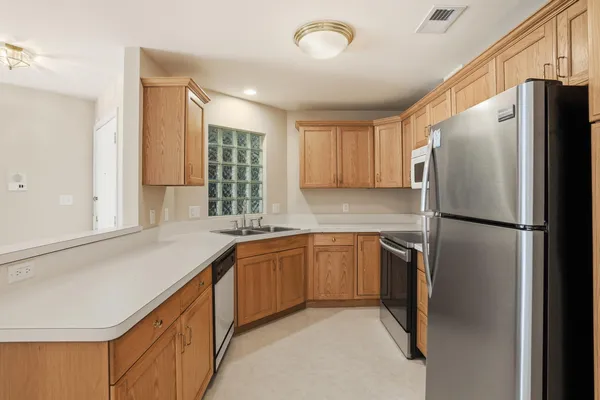 a kitchen with stainless steel appliances granite countertop a refrigerator sink and cabinets