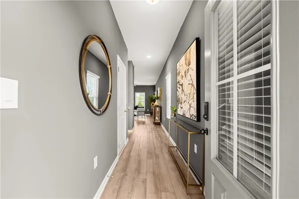 a view of a hallway with wooden floor and staircase