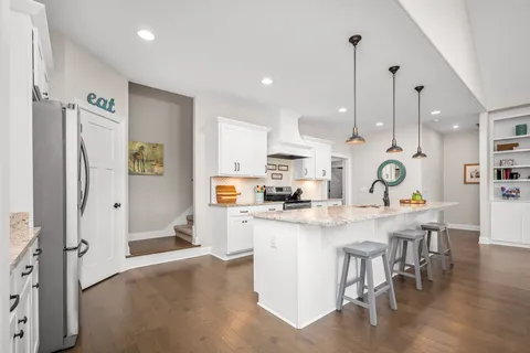a kitchen with stainless steel appliances kitchen island granite countertop a sink a stove and cabinets