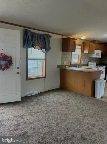 a view of kitchen with stainless steel appliances granite countertop cabinets and window
