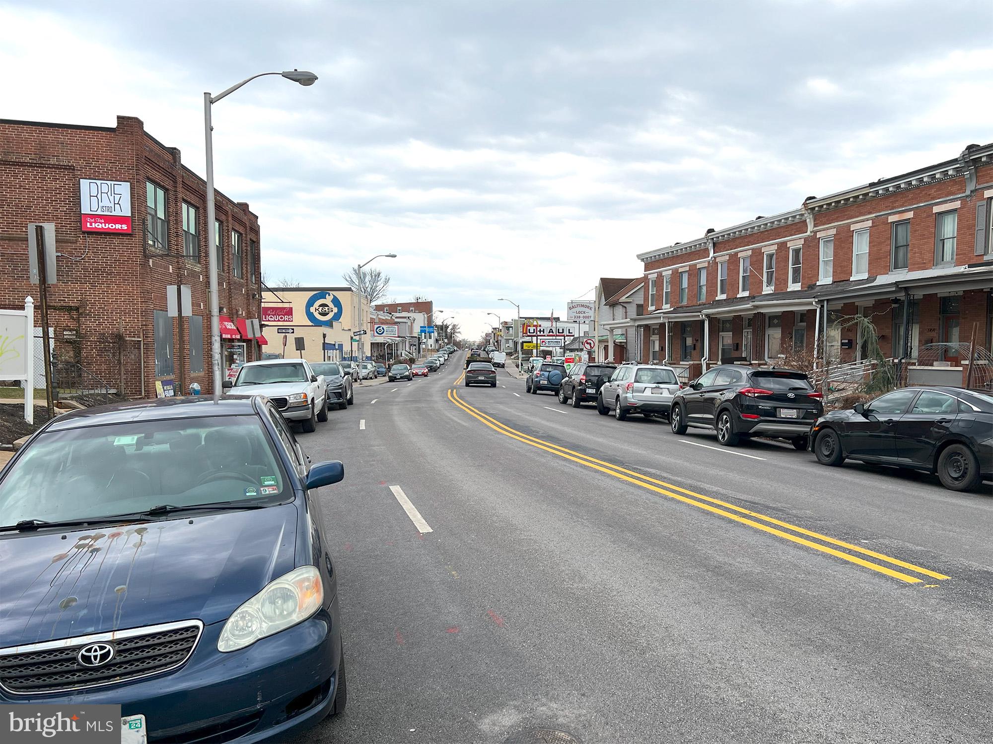 4013 Falls Road Baltimore, MD 21211 - Photo 5 of 7 a city street lined with parked cars and buildings
