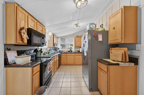 a kitchen with stainless steel appliances granite countertop a refrigerator a stove top oven a sink and dishwasher