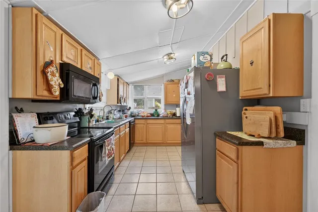 a kitchen with stainless steel appliances granite countertop a refrigerator a stove top oven a sink and dishwasher