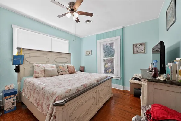 a bedroom with a bed and a flat tv screen on dresser