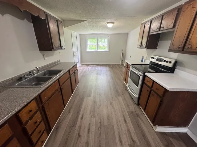 a kitchen with wooden floors and appliances