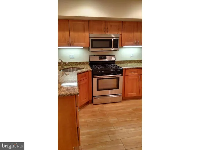 a kitchen with stainless steel appliances granite countertop a sink and cabinets