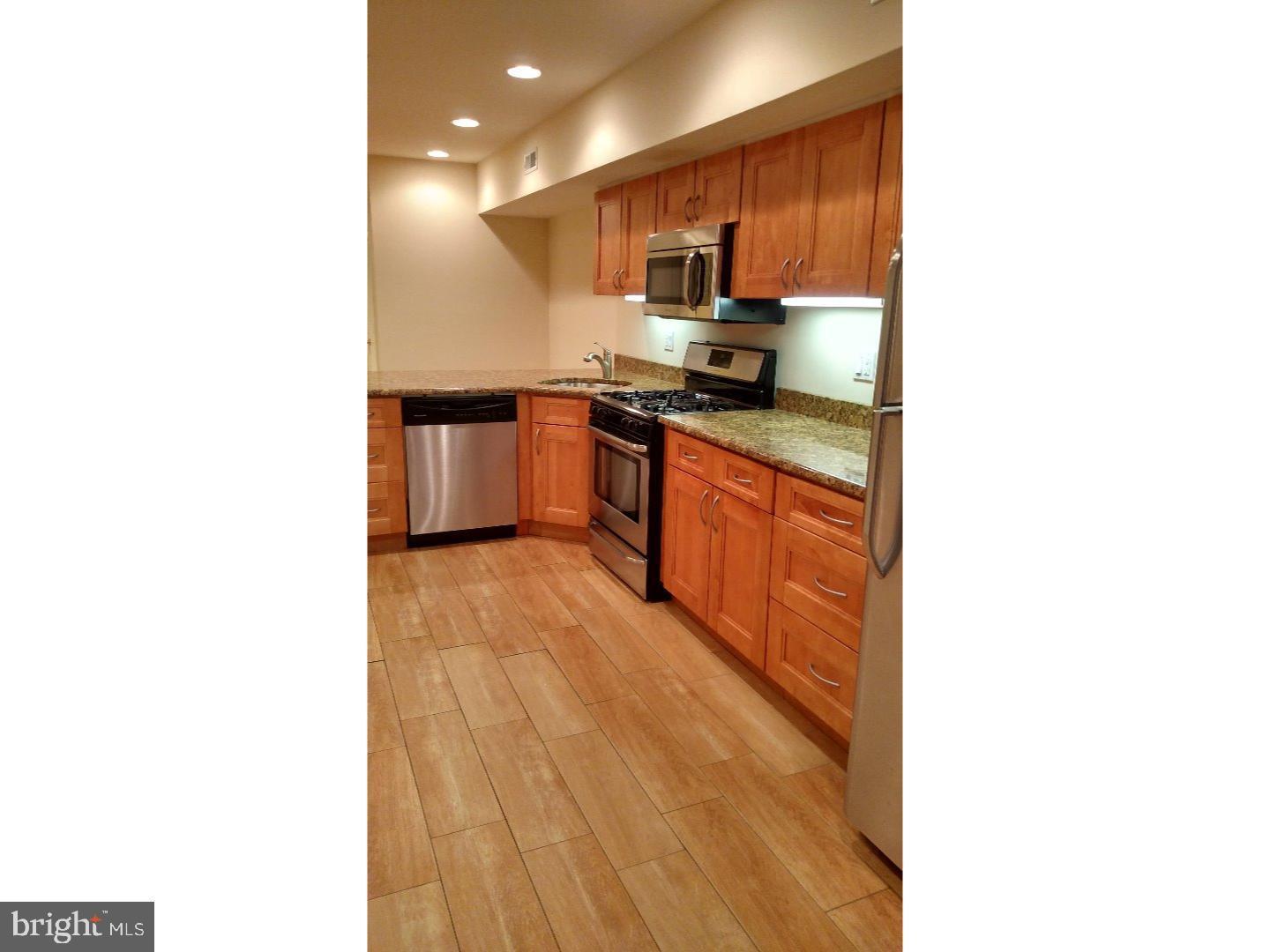 1005 South 8th Street Philadelphia, PA 19147 - Photo 9 of 13 a kitchen with stainless steel appliances granite countertop a sink and cabinets
