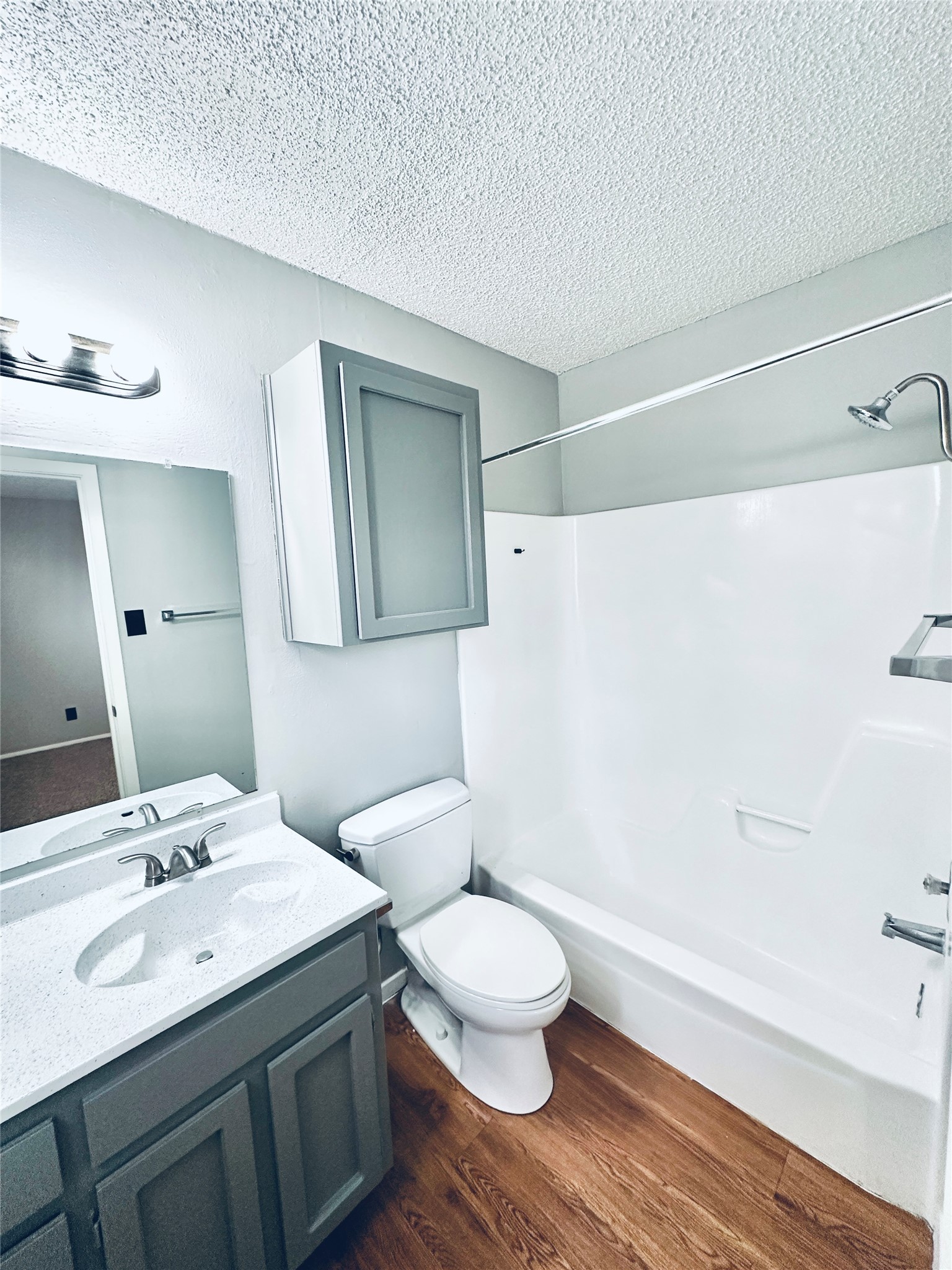 3702 South 2nd Street, Unit 321 Austin, TX 78704 - Photo 12 of 13 Full bath featuring vanity, bathing tub / shower combination, dark wood-style floors, and a textured ceiling
