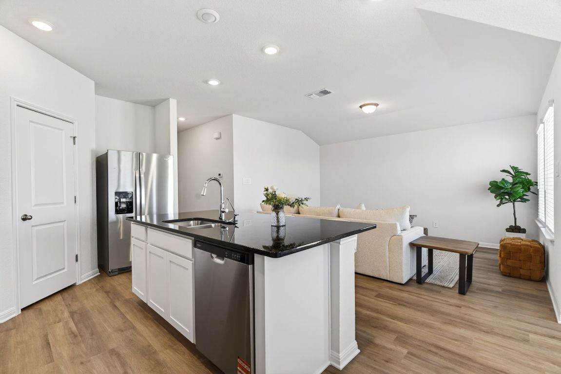 120 Honey Bee Road Jarrell, TX 76537 - Photo 4 of 20 a kitchen with stainless steel appliances kitchen island granite countertop a sink and a refrigerator