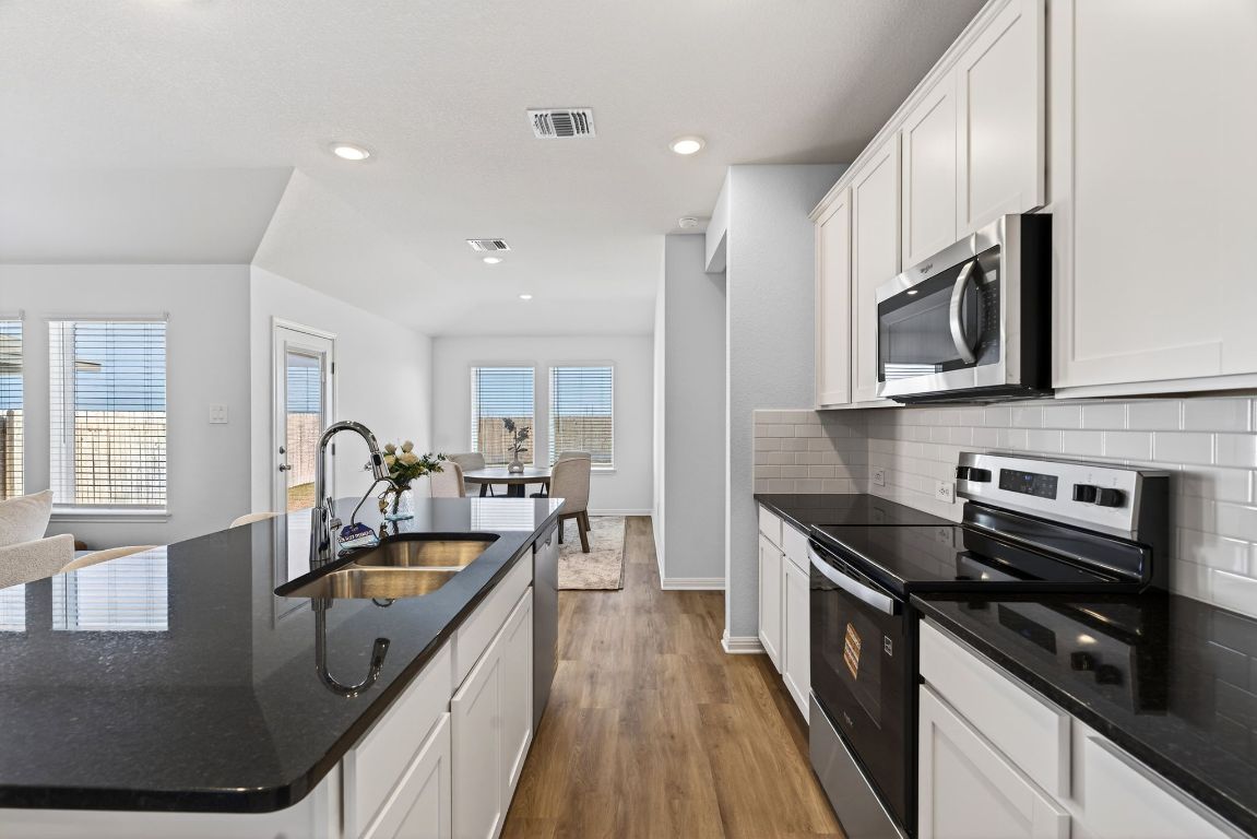 120 Honey Bee Road Jarrell, TX 76537 - Photo 6 of 20 a kitchen with stainless steel appliances granite countertop a sink stove and refrigerator