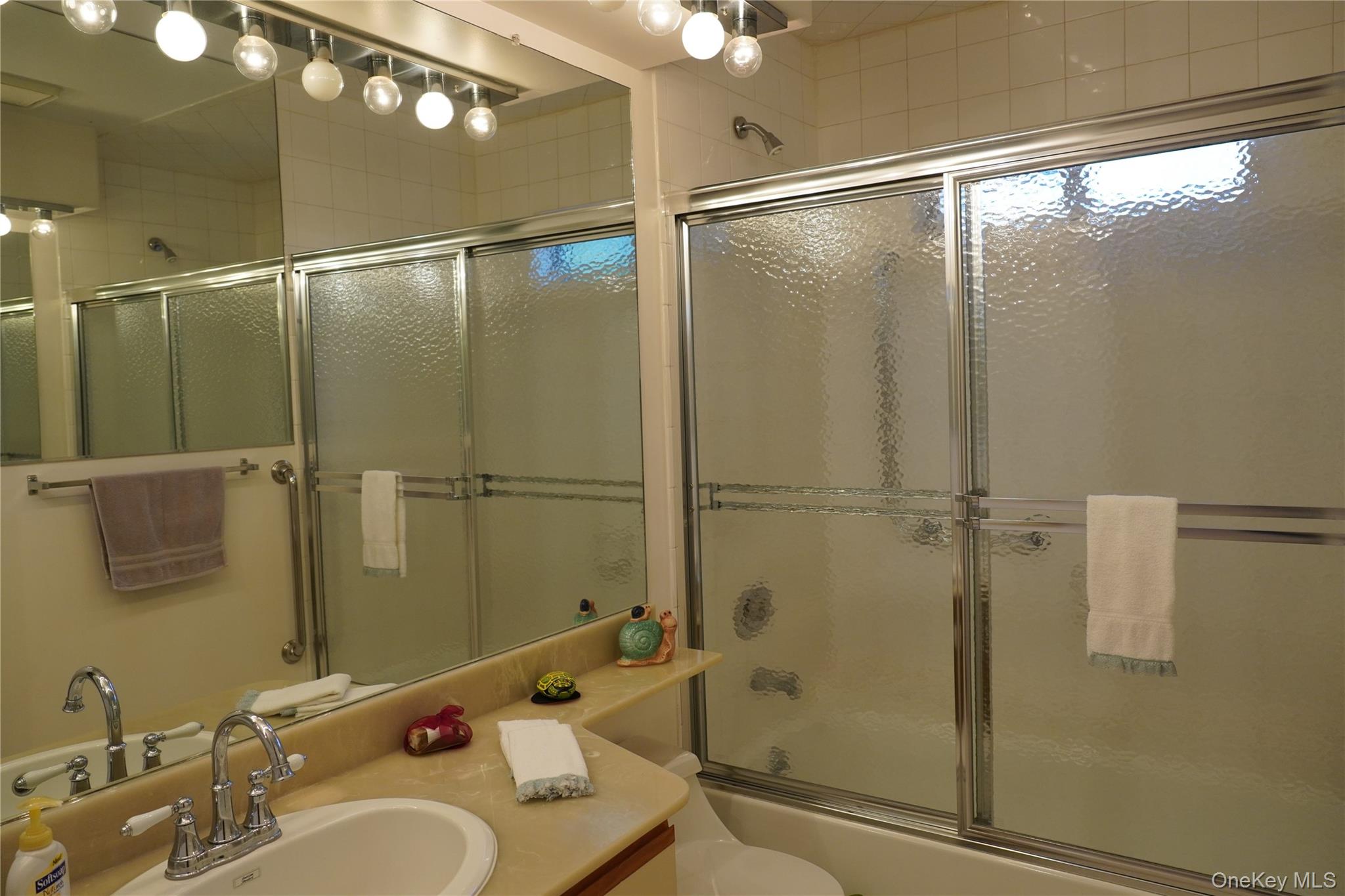 12 Baldwin Court Ridge, NY 11961 - Photo 15 of 15 a bathroom with a shower sink vanity and mirror