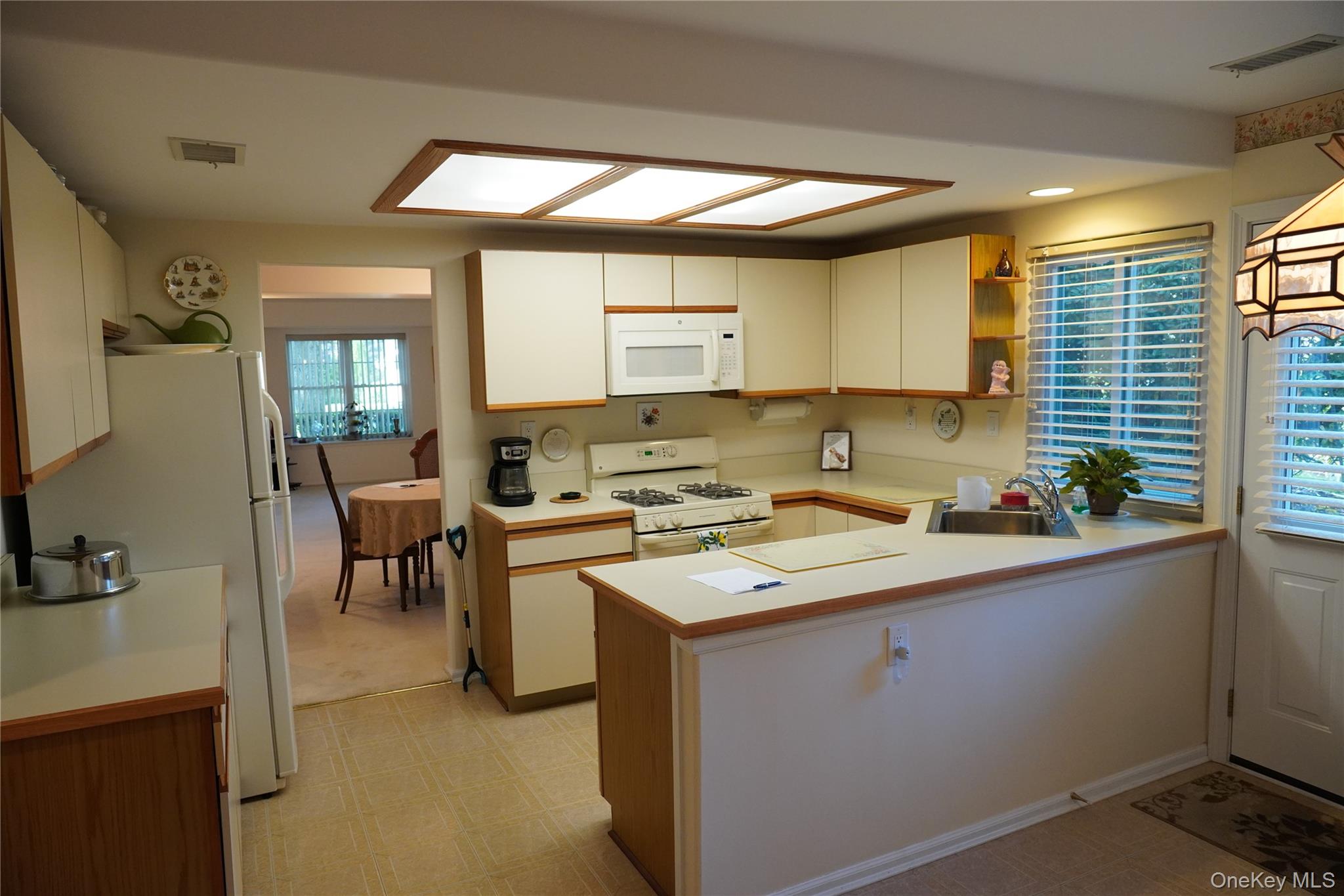 12 Baldwin Court Ridge, NY 11961 - Photo 8 of 15 a kitchen with a sink cabinets and window