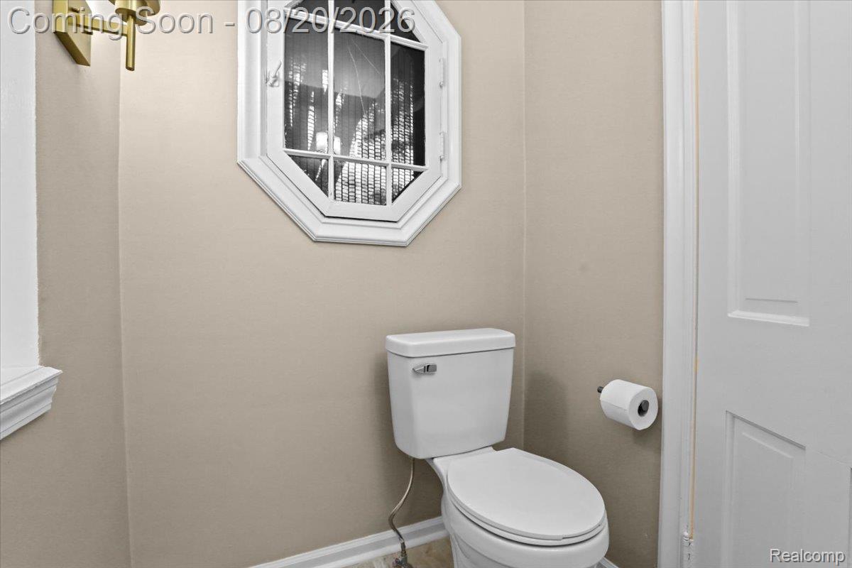 429 Moran Road Grosse Pointe, MI 48236 - Photo 20 of 36 Powder room featuring a two-piece toilet with elongated bowl, ceramic tile flooring, neutral wall finishes, and octagonal wall-mounted cabinet with glass doors for storage
