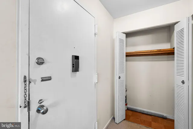 a living room with furniture a flat screen tv and a refrigerator