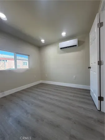 a view of a hallway with wooden floor and a cabinet