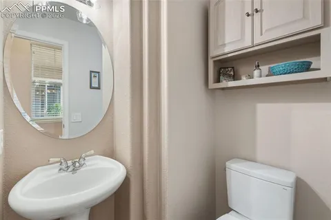 a bathroom with a sink a toilet and a mirror