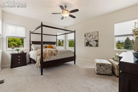 a bedroom with a bed and a chandelier fan