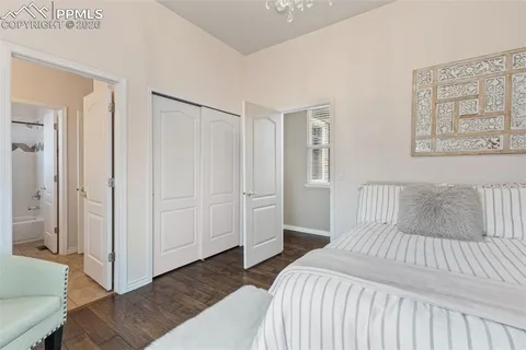 a bedroom with a large bed and wooden floor