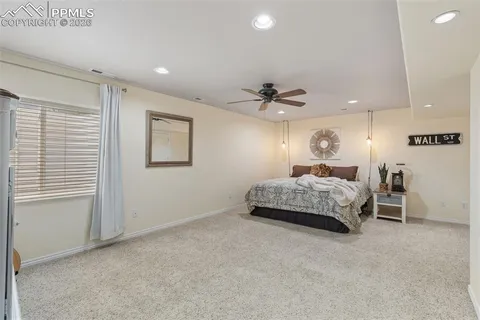 a bedroom with a bed chandelier and a window