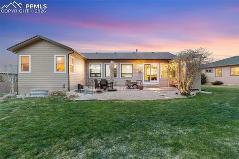 a view of a house with backyard and sitting area