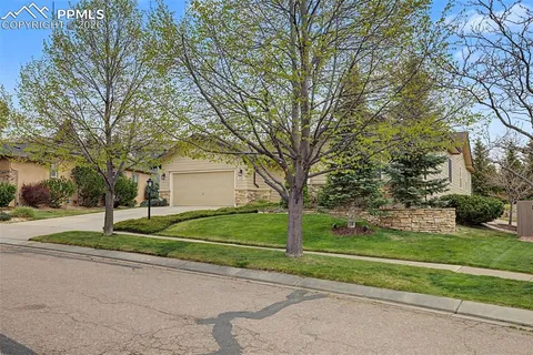 a view of a house with a big yard and large trees