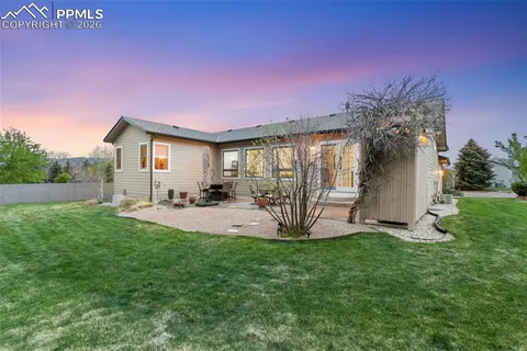 a view of a house with backyard and a tree