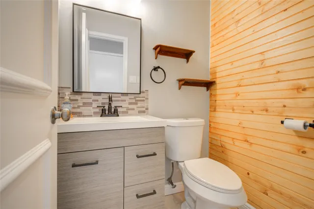 a bathroom with a toilet a sink and mirror