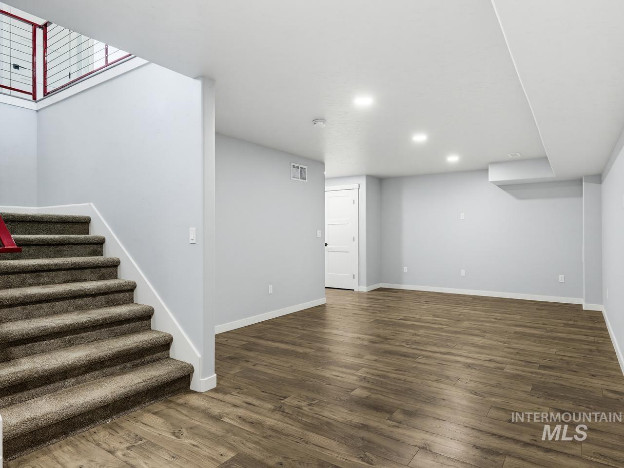 4950 West Columbia Road Nampa, ID 83687 - Photo 31 of 50 Spacious interior featuring wood-finish flooring, recessed lighting, neutral wall tones, white trim, and a carpeted staircase with a modern railing