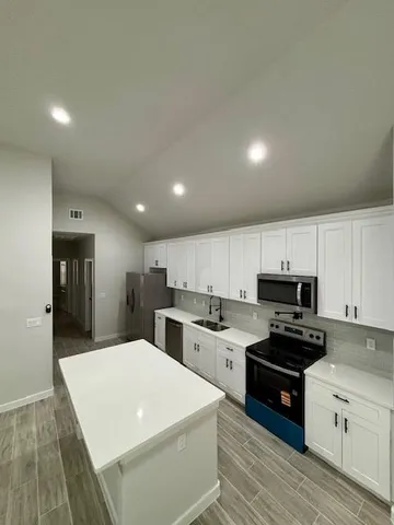 a kitchen with sink a microwave and cabinets