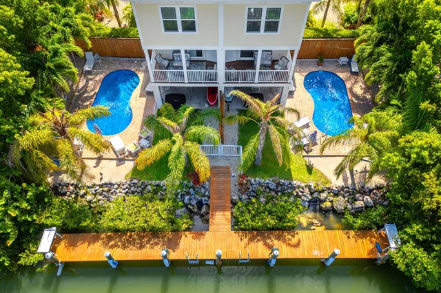 a view of a house with a yard chairs and table in the patio