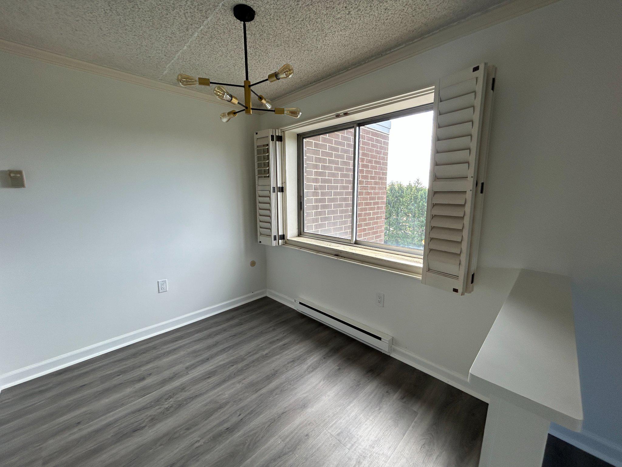 860 Lower Ferry Road, Unit 6M Ewing, NJ 08628 - Photo 8 of 16 a view of an empty room with wooden floor and a window