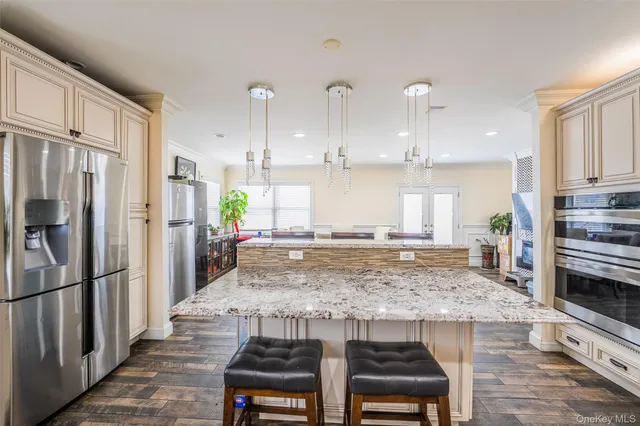 a kitchen with stainless steel appliances granite countertop a sink refrigerator and cabinets