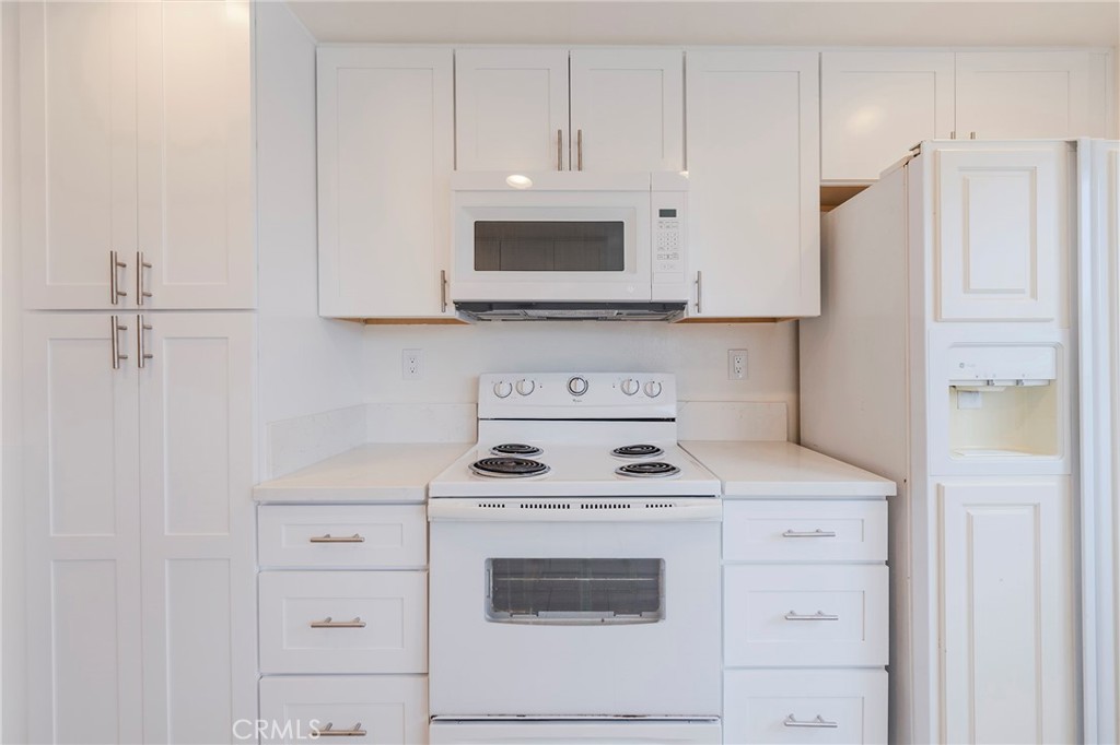 263 Tarocco Irvine, CA 92618 - Photo 11 of 34 a kitchen with white cabinets and white appliances
