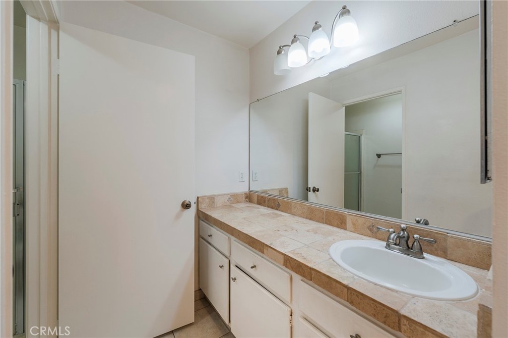 263 Tarocco Irvine, CA 92618 - Photo 20 of 34 a bathroom with a granite countertop sink and a mirror