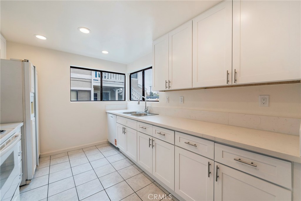 263 Tarocco Irvine, CA 92618 - Photo 10 of 34 a kitchen with granite countertop white cabinets and white appliances