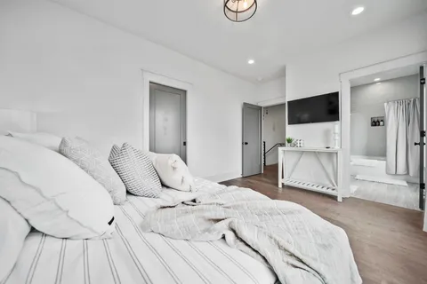 a spacious bedroom with a bed and a flat screen tv