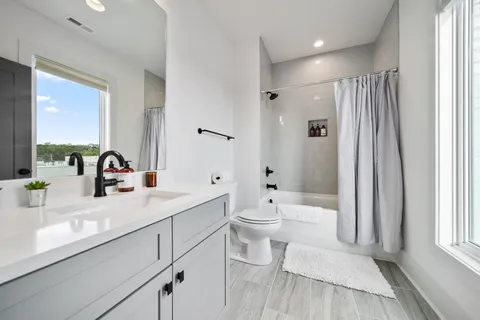 a bathroom with a sink a toilet and a large mirror