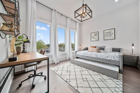 a bedroom with a bed a table and a potted plant
