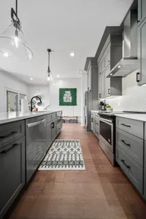 a kitchen with stainless steel appliances granite countertop a sink stove and cabinets