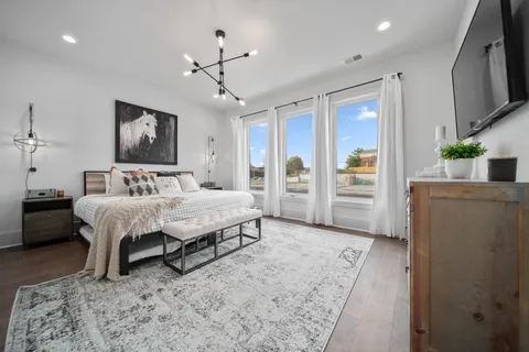a bedroom with a bed dresser and a flat screen tv