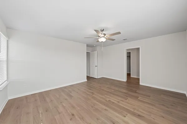 a view of an empty room with wooden floor