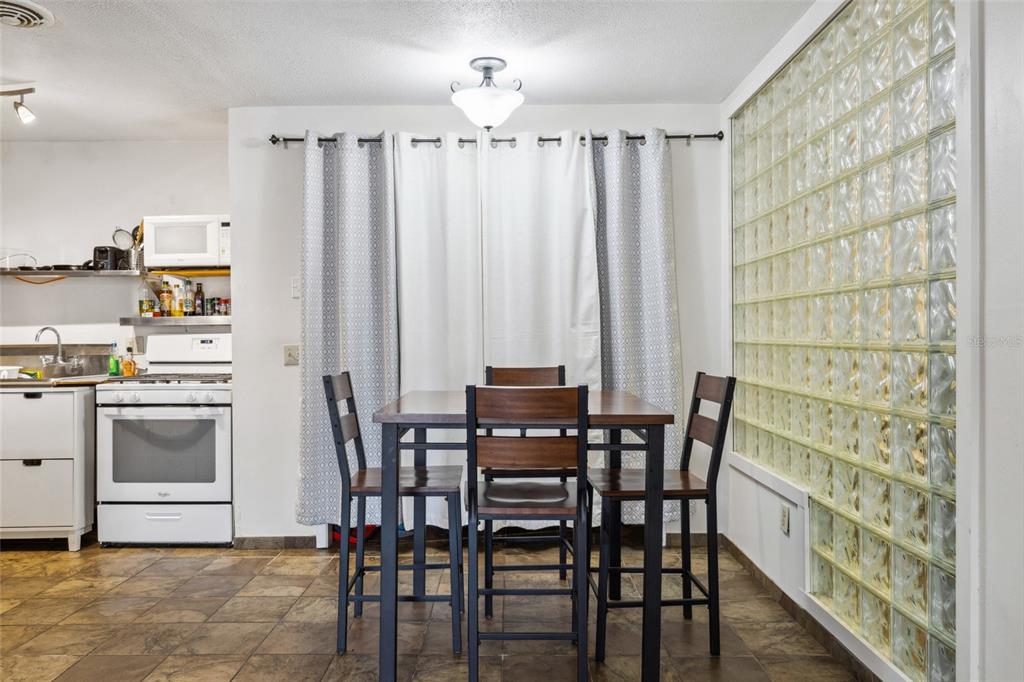 1700 Southwest 16th Court, Unit M2 Gainesville, FL 32608 - Photo 5 of 13 a view of a dining room with furniture and chandelier