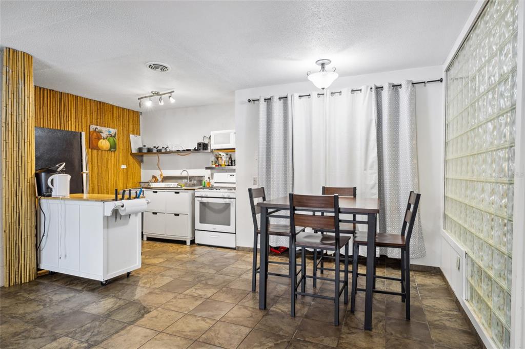 1700 Southwest 16th Court, Unit M2 Gainesville, FL 32608 - Photo 6 of 13 a kitchen with a table chairs sink and cabinets