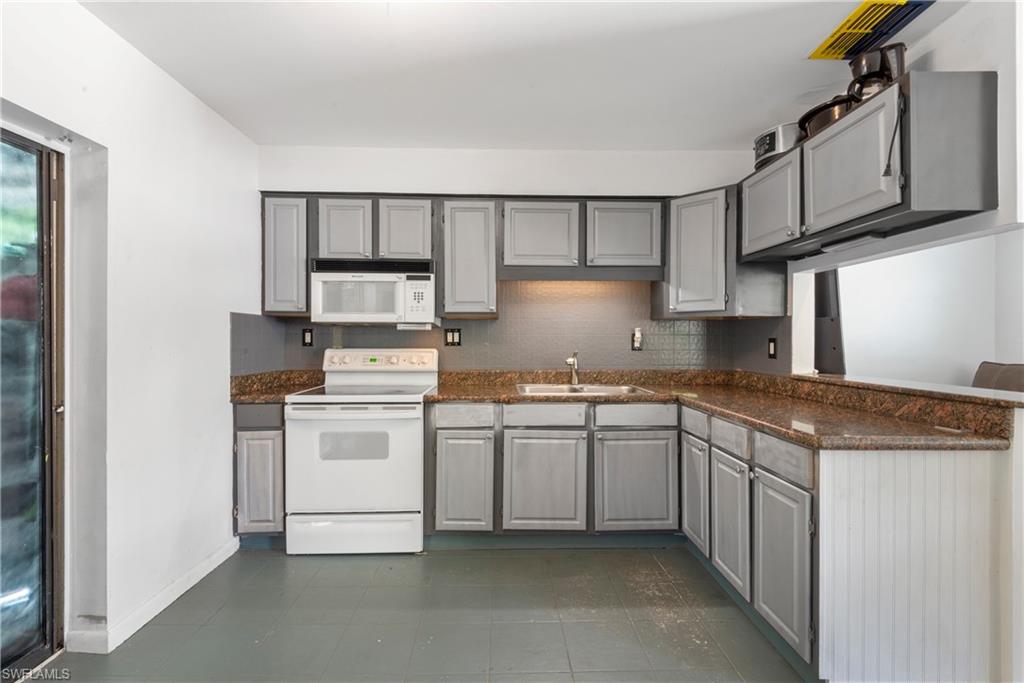 19053 Holly Road Fort Myers, FL 33967 - Photo 8 of 21 a kitchen with stainless steel appliances granite countertop a stove and a sink