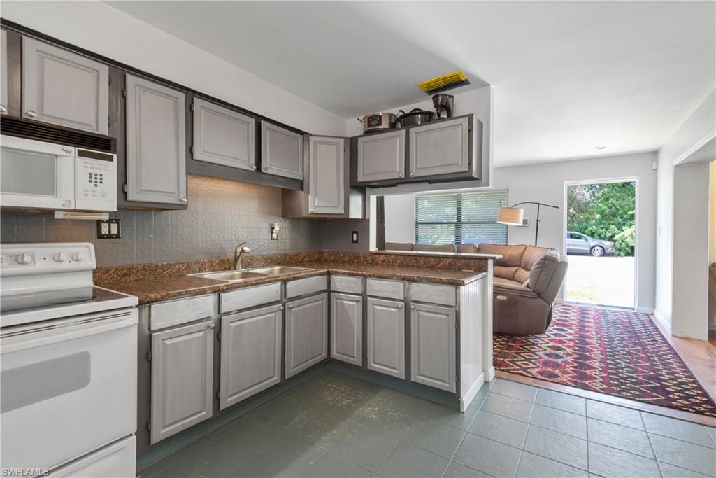 19053 Holly Road Fort Myers, FL 33967 - Photo 9 of 21 a kitchen with stainless steel appliances granite countertop a sink stove and cabinets