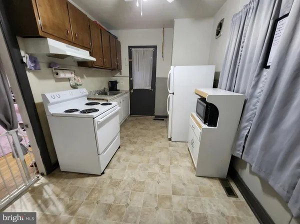 a kitchen with a refrigerator a stove top oven a sink and a refrigerator