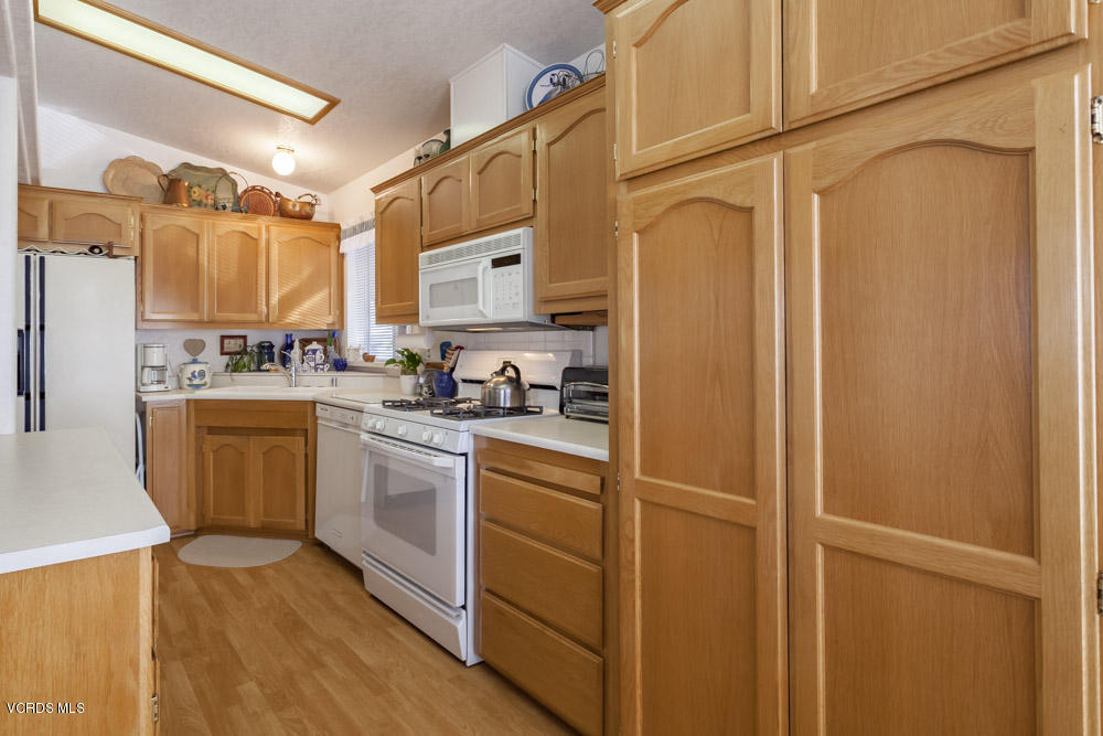 15750 Arroyo Drive, Unit 32 Moorpark, CA 93021 - Photo 13 of 26 a kitchen with stainless steel appliances a refrigerator and cabinets