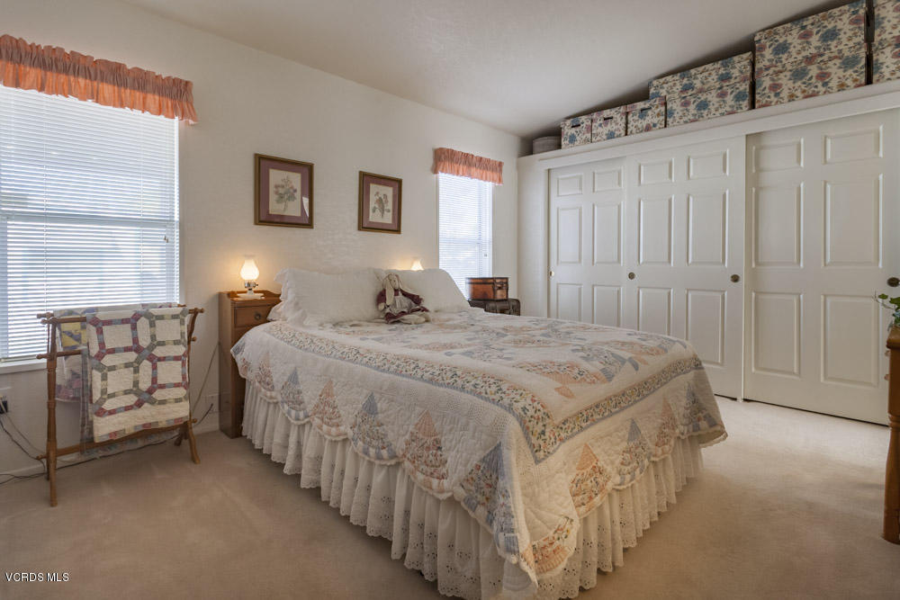 15750 Arroyo Drive, Unit 32 Moorpark, CA 93021 - Photo 20 of 26 a bedroom with a bed a mirror and a window