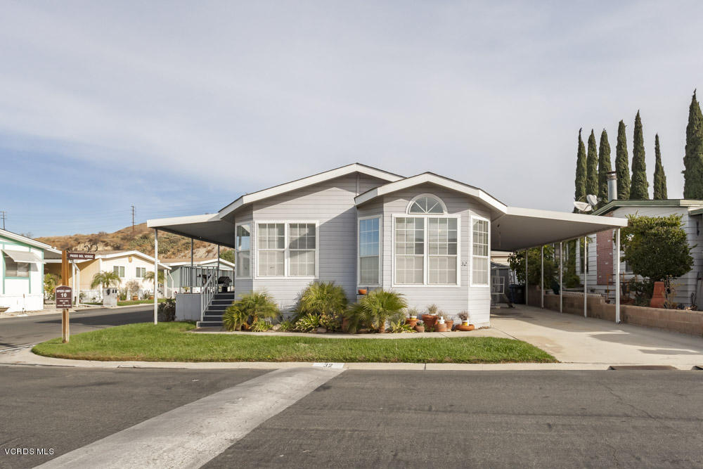 15750 Arroyo Drive, Unit 32 Moorpark, CA 93021 - Photo 3 of 26 a view of a white house next to a yard and road